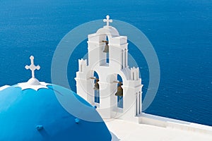 Sunset over aegean sea with view to Virgin Mary Catholic Church Three Bells of Fira, Santorini.