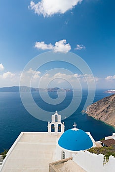 Sunset over aegean sea with view to Virgin Mary Catholic Church Three Bells of Fira, Santorini.