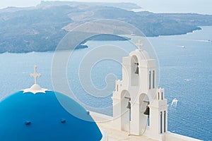 Sunset over aegean sea with view to Virgin Mary Catholic Church Three Bells of Fira, Santorini.