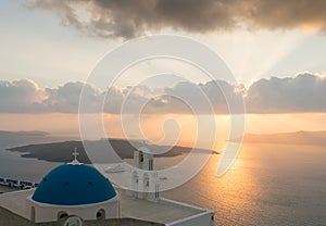 Sunset over aegean sea with view to Virgin Mary Catholic Church Three Bells of Fira, Santorini.