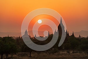 Sunset over ancient temples, pagodas and stupas in Old Bagan, Myanmar Peaceful Asian landscape with Buddhist temple silhouettes.