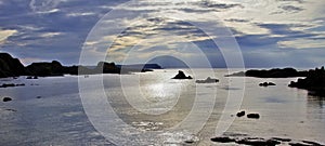 Sunset over the Antrim Coast silhouetting rocky Islands, Balintoy