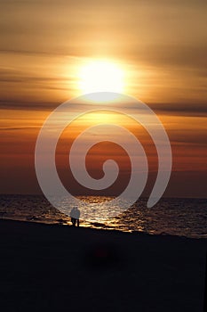 Sunset over the Baltic sea in Poland Europe with a couple of people in love on the beach