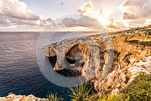 Sunset over the Blue Grotto, a rock formation in Malta.