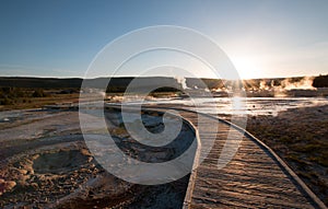 Sunset over boardwalk at the Old Faithful geyser basin in Yellowstone National Park in Wyoming USA