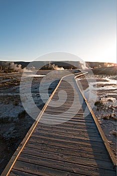 Sunset over boardwalk at the Old Faithful geyser basin in Yellowstone National Park in Wyoming USA