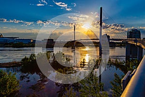 Sunset over Bob Kerrey Pedestrian bridge and swollen Missouri River at Omaha Riverfront