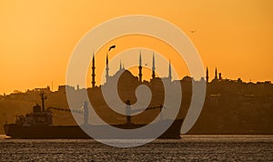 Sunset over the Bosporus. Istanbul, silhouette of a cargo ship on the background of the Blue Mosque