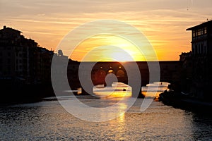 Sunset over bridges through the river Arno