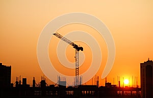 Sunset over Building construction in the city. Crane and structure silhouettes