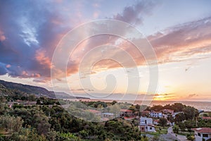 Sunset over Calabria coast with village next to the Tropea town in Vibo Valentia, Calabria, Southern Italy