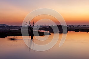 Sunset over calm Taungthaman lake in Myanmar near.