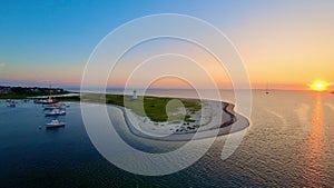 Sunset over Cape Cod coastline with lighthouse