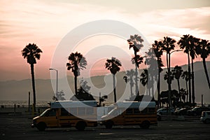 Sunset over car park with two school bus camper