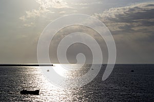 Sunset over the city bay with boats and pier in the background