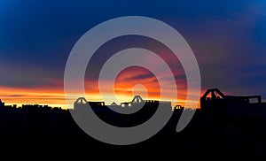 Sunset over the city. Beautiful bright colors at sky. Orange and blue sky.