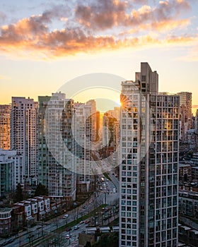 Sunset over a city skyline with a road winding between buildings. Pacific Blvd and False Creek in Vancouver