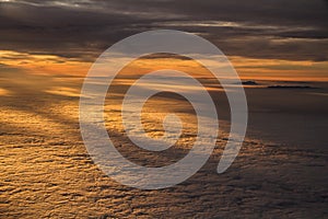 Sunset over Clouds with Mountain Tops from Plane