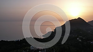 Sunset over coast of Corfu with Saint George mountain, Greece.