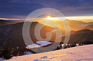 Sunset over color mountain silhouette with rays photo