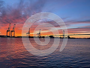 Sunset over Delaware River at Walt Whitman Bridge and Philadelphia Port