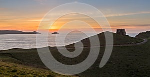 Sunset over Doyden Castle on coastline at Port Quin