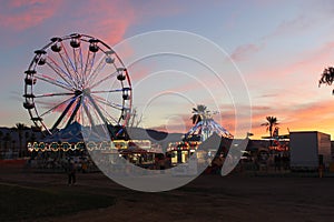 Sunset over Ferris Wheel and Carnival Rides