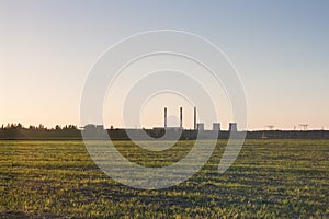 Sunset over the field with the city on the horizon