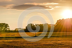 Sunset over a field path with a lamp.