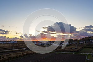 Sunset over the fields, village in the sun