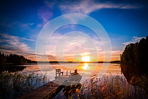Sunset over the fishing pier at the lake in Finland