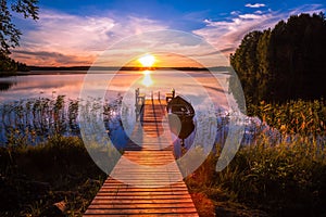 Sunset over the fishing pier at the lake in Finland photo