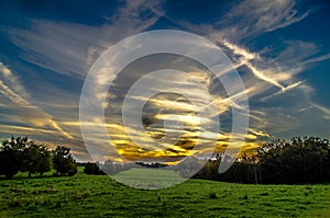 Sunset over green field farm land