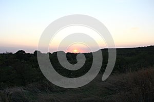 Sunset over hills and trees