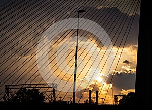 Sunset over industrial part of town - seen through suspension cables
