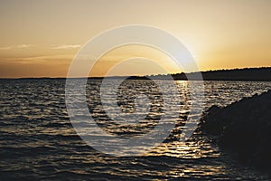 Sunset over island on Mediterranean Sea during summer season