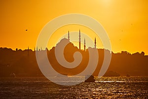 Sunset over Istanbul Silhouette wih City line ferry and boats. Traditional arabic town with silhouettes of minarets on sunset,