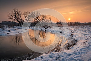 Sunset over the Jeziorka river at winter near Piaseczno, Masovia, Poland