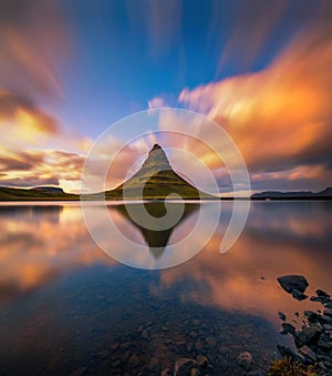 Sunset over Kirkjufell mountain with reflection in a nearby lake in Iceland