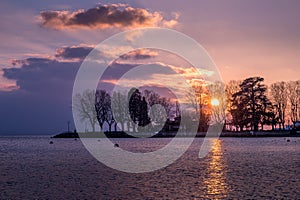 Sunset over lake with backgrounds of trees and clouds in Lausanne, Switzerland.