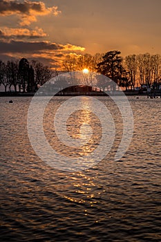 Sunset over lake with backgrounds of trees and clouds in Lausanne, Switzerland.