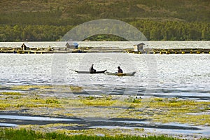 Sunset over Lake Batur. Two fishermen in their boats on Lake Batur, Bali Island, Indonesia.