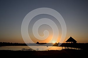 Sunset over lake & hut on stilts, Kenya