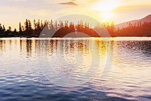 Sunset over the lake. Majestic mountain lake in National Park High Tatra. Strbske pleso, Slovakia