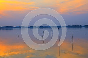 Sunset over lake , Man rows a fishing boat
