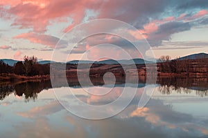 Sunset over lake with pink clouds