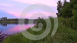 Sunset over the lake. Pink clouds lit by the setting sun. Calm and pacification of nature