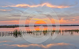 Sunset over lake with riverbank campshedding