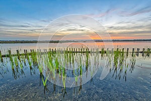 Sunset over lake with shore protection and riparian zone