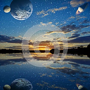 Sunset over the lake on a sky background with planets